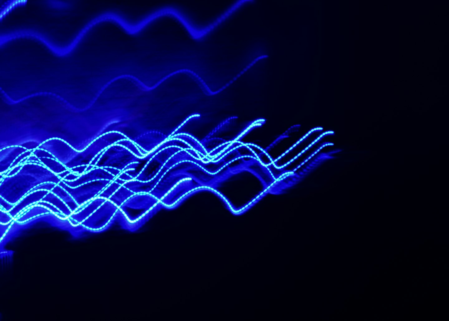 Electric blue wavy lines traverse a dark black background.